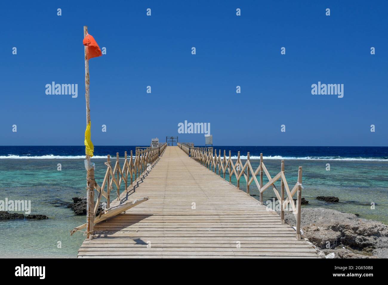 Drapeau rouge sur la longue jetée par temps ensoleillé Banque D'Images