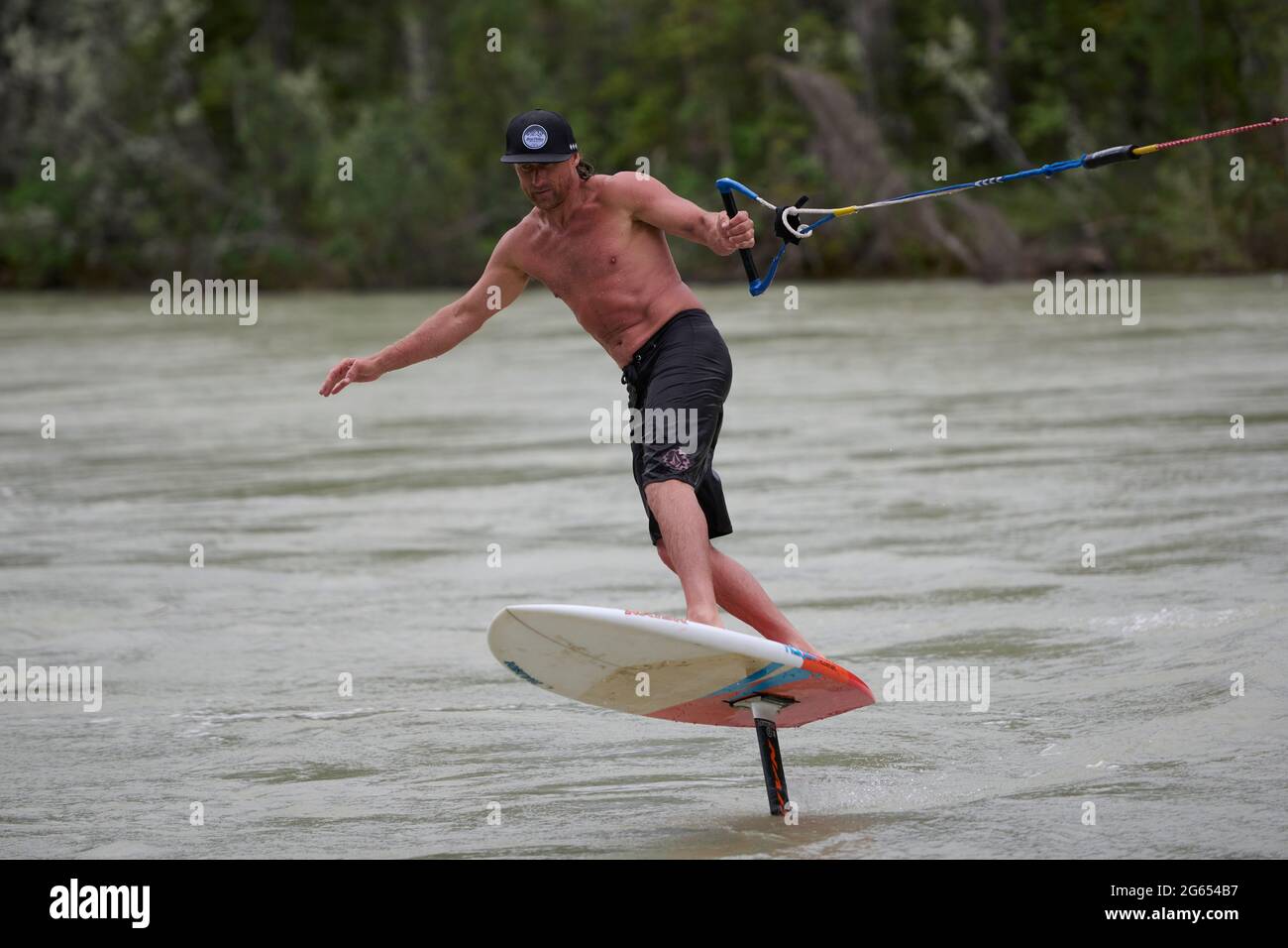 Todd Rice planche à voile (planche à voile) pendant le ruissellement printanier à débit élevé dans la rivière Bow, Canmore, Alberta, Canada. Banque D'Images