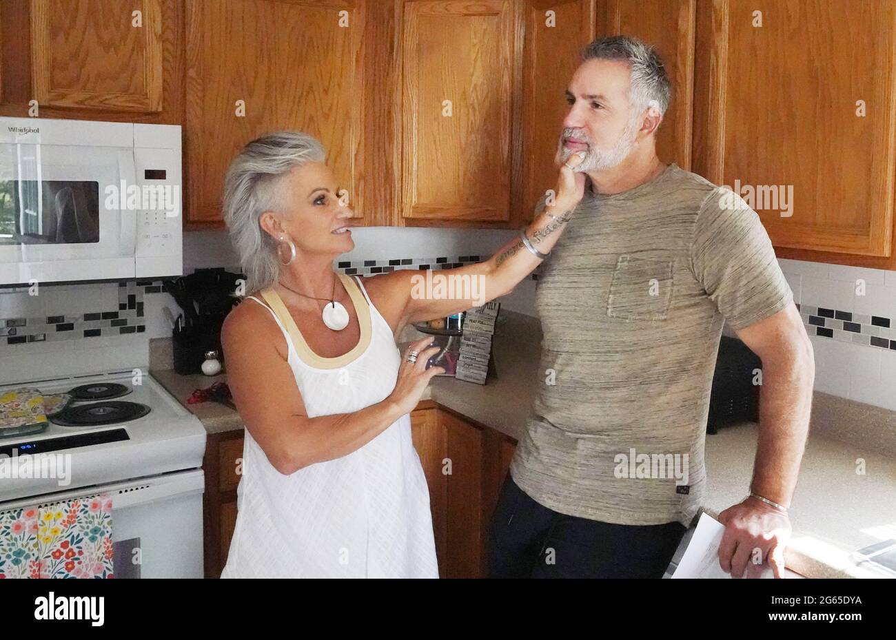 Alton, États-Unis. 02 juillet 2021. Brenda Warner, épouse du quarterback du Temple de la renommée Kurt Warner, touche sa barbe grise alors que les deux attendent l'arrivée de la famille Krikelas à Alton, Illinois, le vendredi 2 juillet 2021. La Kurt Warner First Things First Foundation a surpris 54 familles en leur fournissant leurs nouvelles maisons avec tout ce dont la famille a besoin pour faire de leur nouvelle maison Habitat, une maison. Photo par Bill Greenblatt/UPI crédit: UPI/Alay Live News Banque D'Images