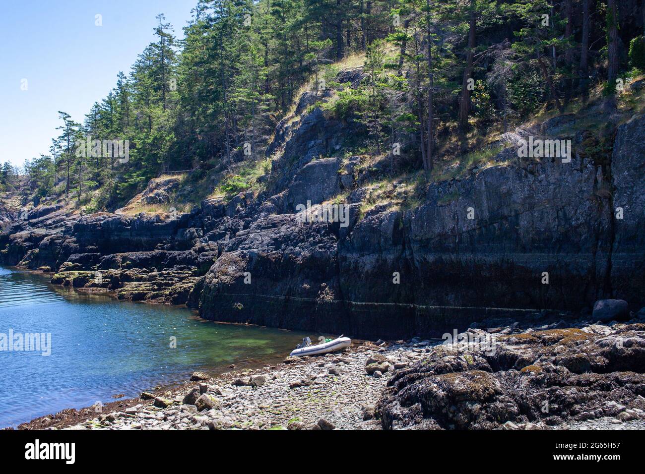 Un petit canot de zodiaque est décapé sur un rivage rocheux au large de l'île Thormanby Banque D'Images