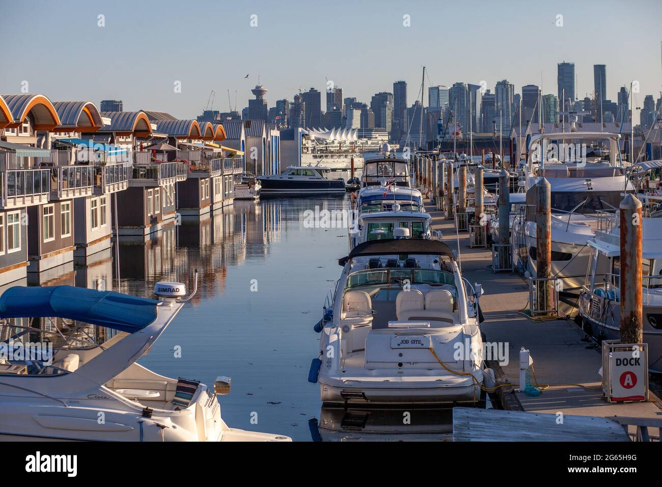 Des bateaux à moteur flottants colorés et mignons bordent les quais de la marina de Mosquito Creek, North Vancouver, Colombie-Britannique. Ce logement alternatif est en pleine croissance Banque D'Images