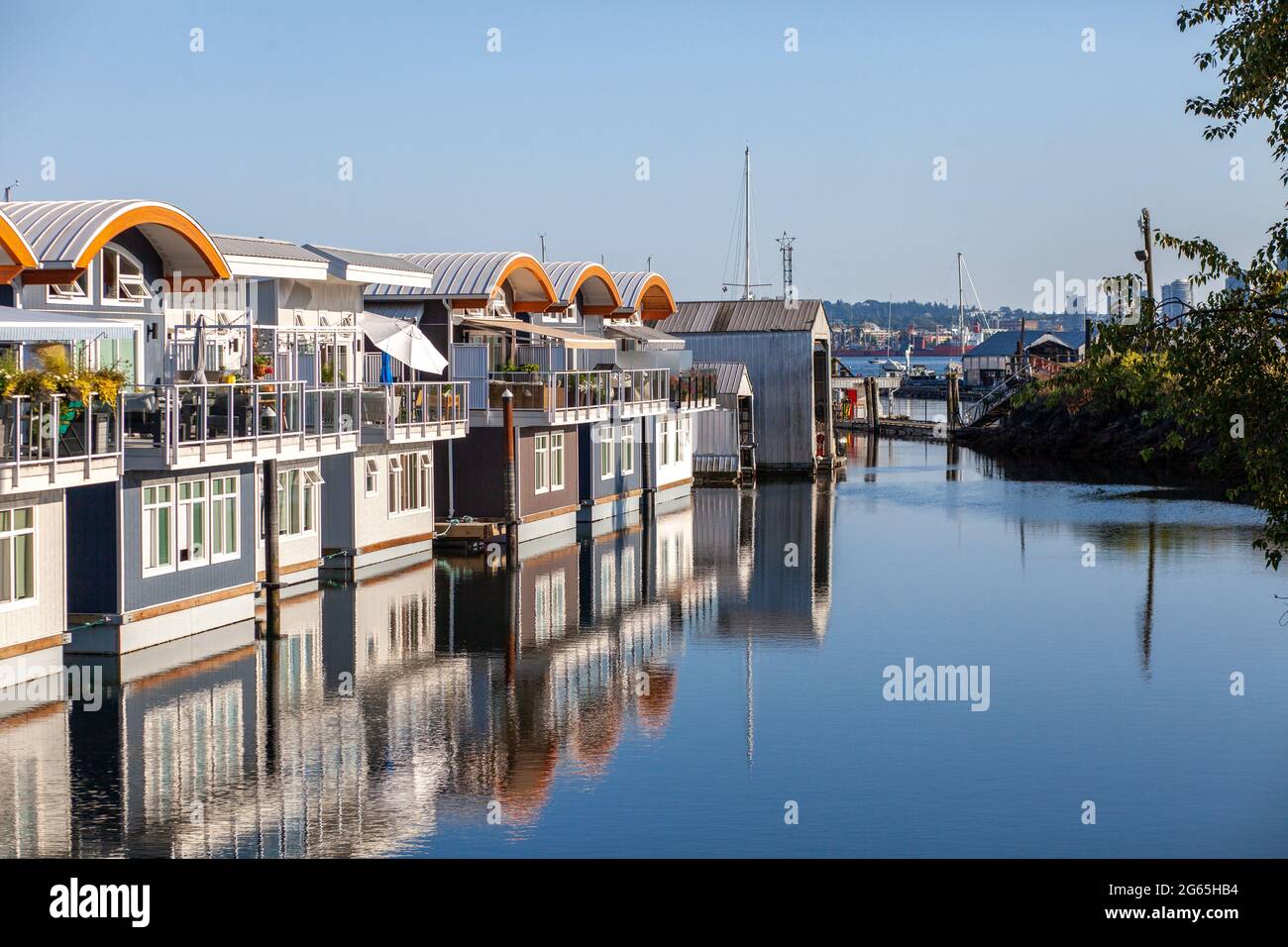 Des bateaux à moteur flottants colorés et mignons bordent les quais de la marina de Mosquito Creek, North Vancouver, Colombie-Britannique. Ce logement alternatif est en pleine croissance Banque D'Images