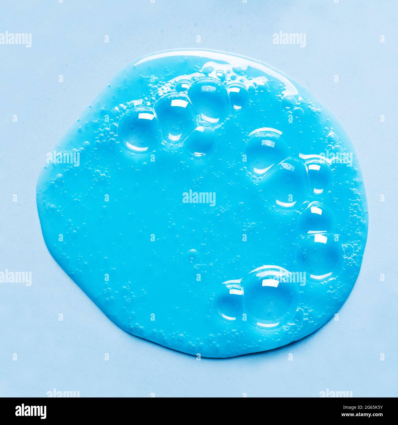 Flaque d'échantillon de shampooing ou gel douche bleu sur fond bleu. Produit cosmétique Blue Gel avec bulles. Banque D'Images
