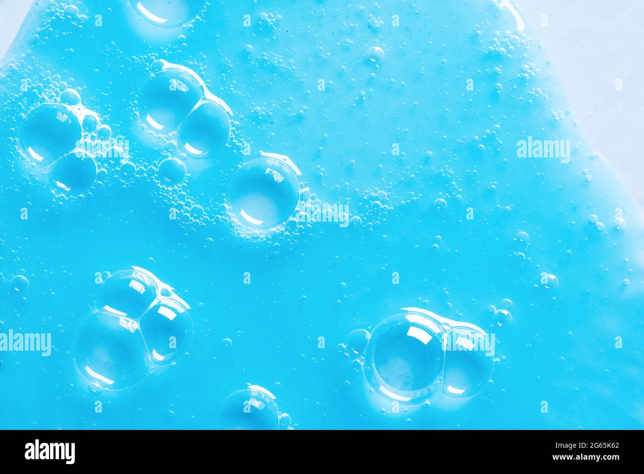 Texture bleue du shampooing ou du gel douche sur fond bleu. Produit cosmétique avec gel nettoyant et bulles. Banque D'Images