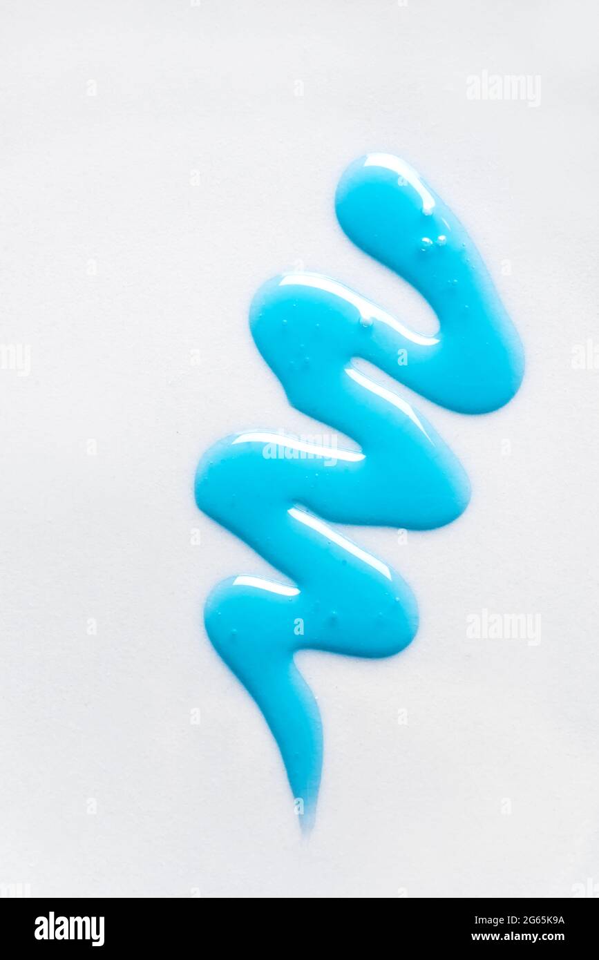 L'échantillon de shampooing bleu ou de gel douche tombe sur fond blanc. Nuance de vague de produit cosmétique Blue Gel. Banque D'Images