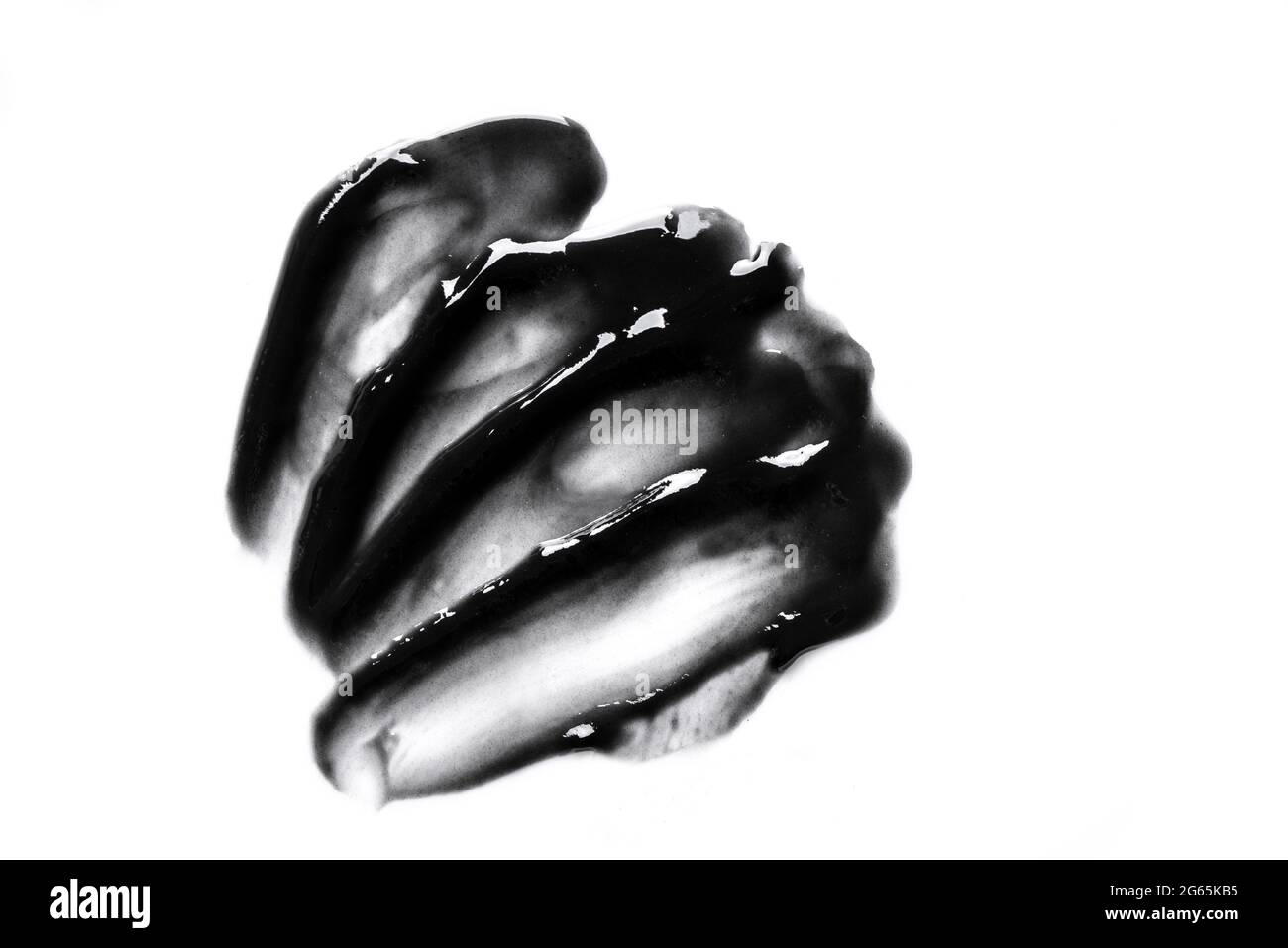 Échantillon de gel cosmétique noir isolé sur fond blanc. Gros plan sur les contours de texture du masque noir anthracite. Banque D'Images