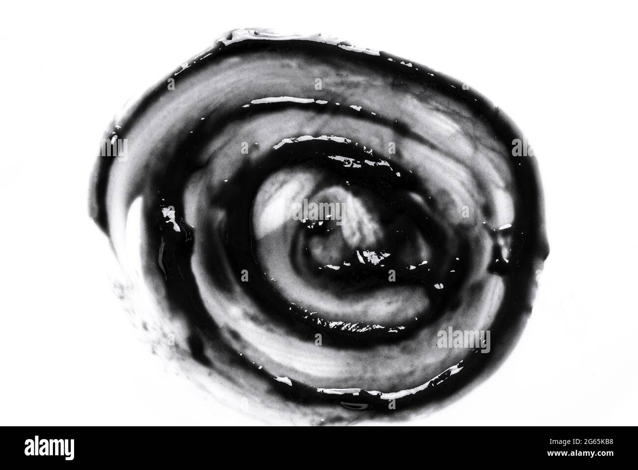 Échantillon de gel cosmétique noir isolé sur fond blanc. Masque noir de charbon de bois texture tourbillon de gros plan. Banque D'Images