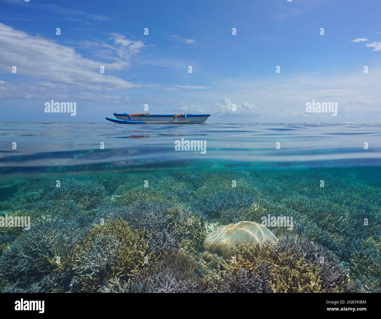 Paysage marin tropical, canoë en saillie à la surface et récif corallien sous l'eau, vue partagée sur et sous l'eau, Polynésie, océan Pacifique Banque D'Images