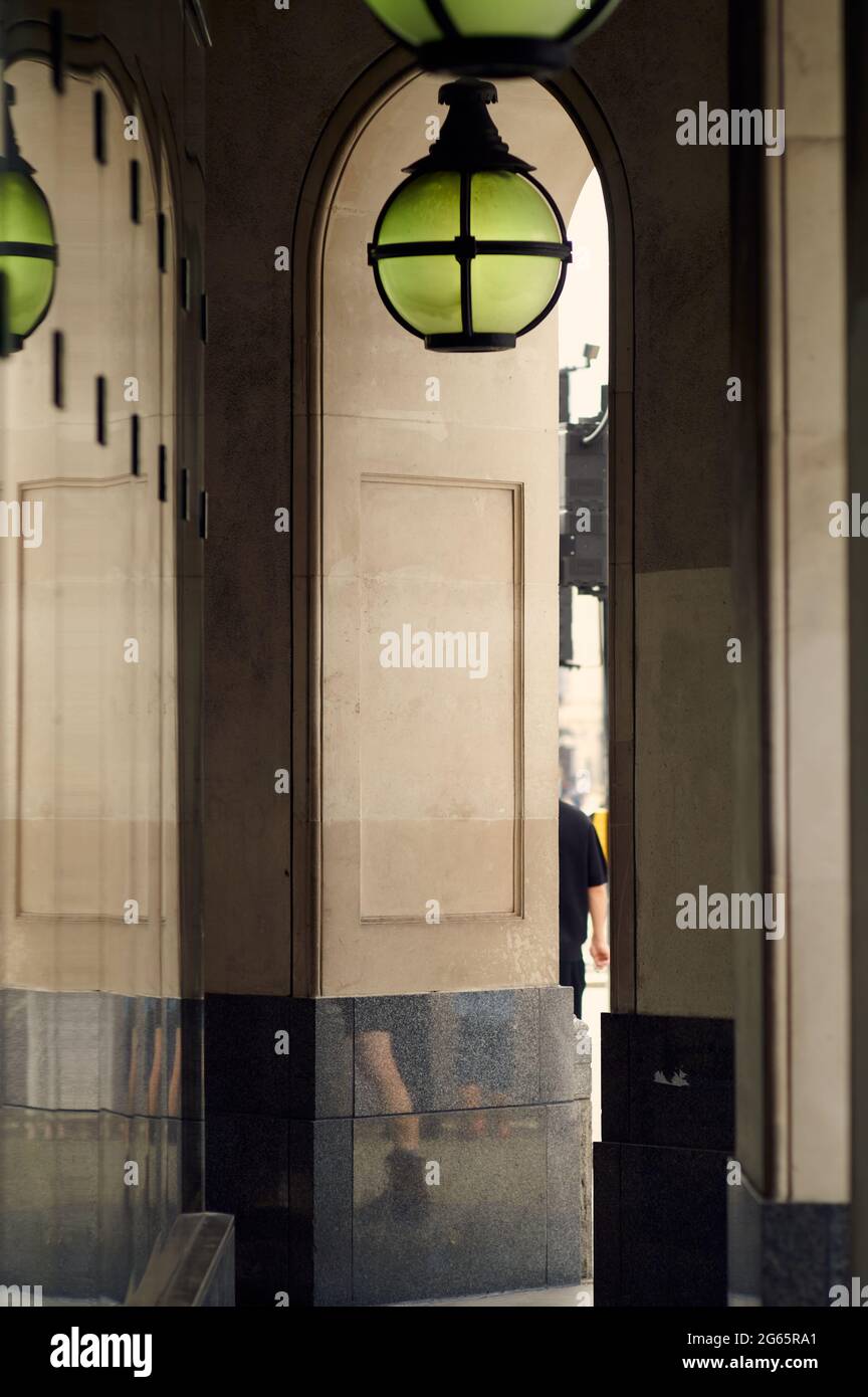 Vue sur le passage couvert à côté de l'arcade contemporaine de luxe bâtiment montrant des lignes verticales, vue partielle d'une personne et réfec lumineux orné Banque D'Images