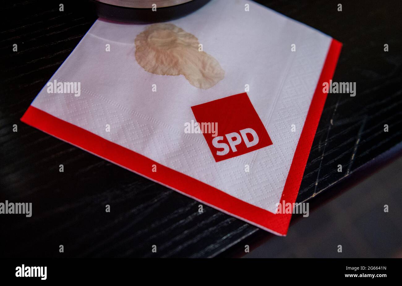 03 juillet 2021, Saxe, Leipzig: Une tache de café est visible sur une serviette avec le logo SPD à la convention d'état du parti à Leipzig. Sous la devise « du mode de crise au mode futur », les délégués discutent d'une motion de premier plan traitant des effets de la pandémie de Corona et établissant les lignes directrices pour le travail futur des sociaux-démocrates dans l'État libre. Photo: Hendrik Schmidt/dpa-Zentralbild/dpa Banque D'Images