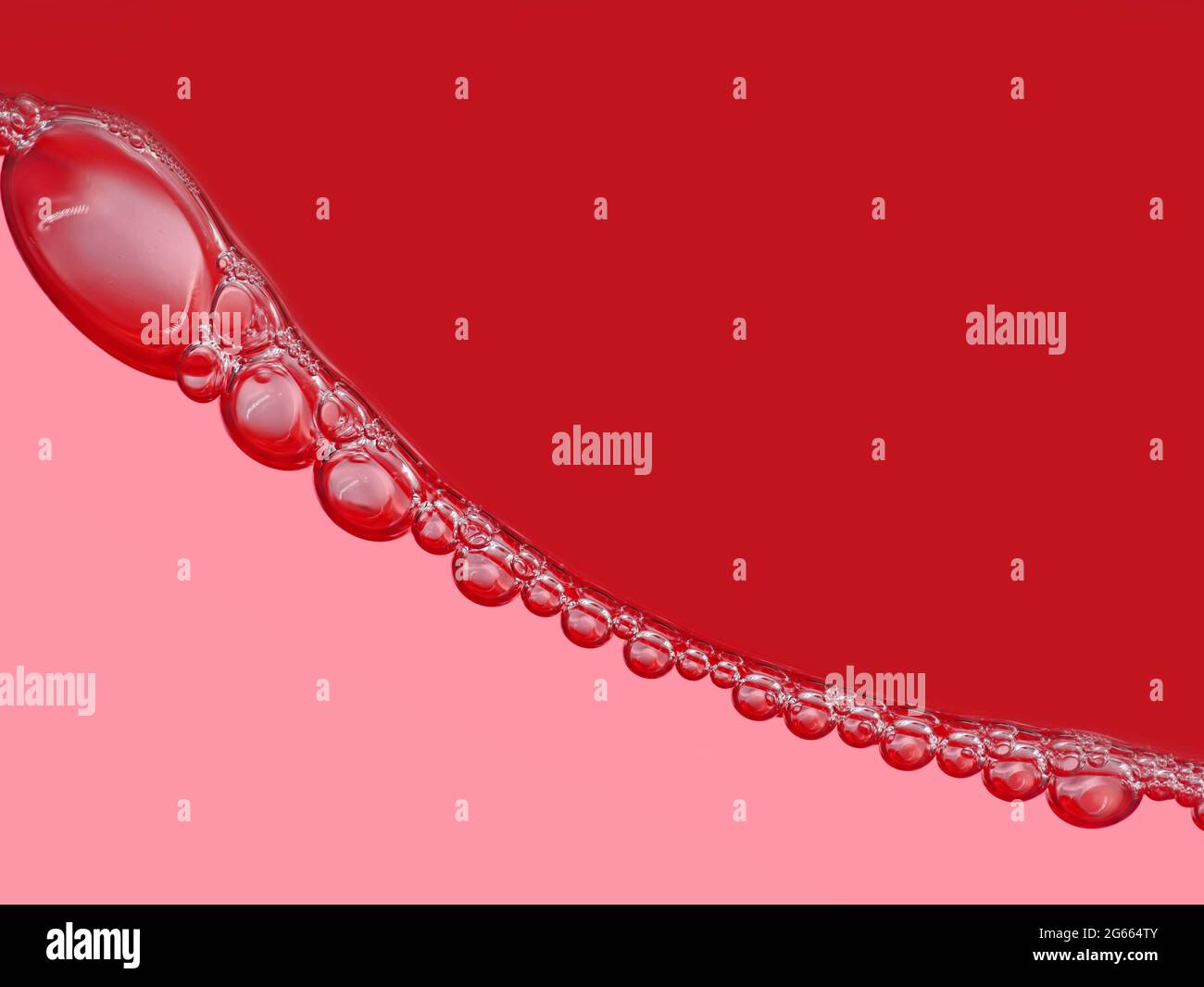 chaîne à bulles sur la surface en boisson gazeuse rouge, gros plan, arrière-plan rouge abstrait des bulles Banque D'Images