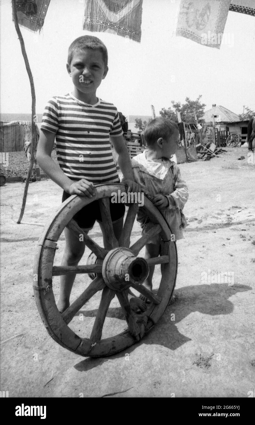 Enfants dans la cour de leur maison dans la campagne roumaine. Environ 1990. Banque D'Images