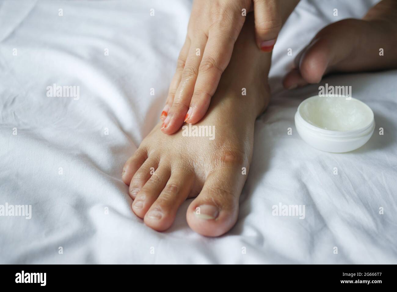 femme appliquant de la vaseline sur les pieds du lit Photo Stock - Alamy