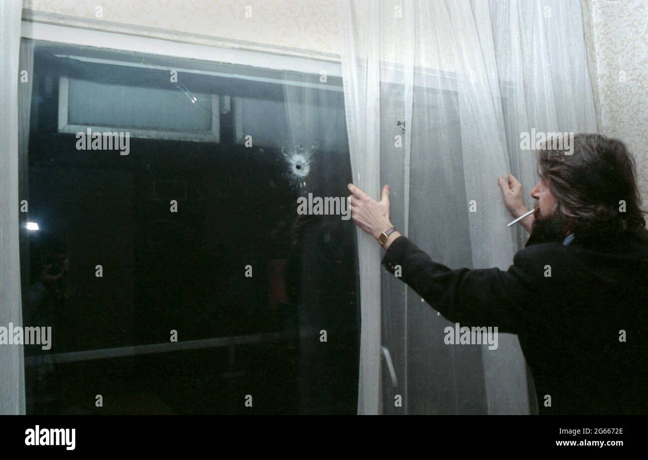 1990 janvier, Bucarest, Roumanie. Eugen Mihaescu regardant un trou de balle à travers la fenêtre de la chaîne de télévision publique roumaine après la Révolution roumaine. Banque D'Images