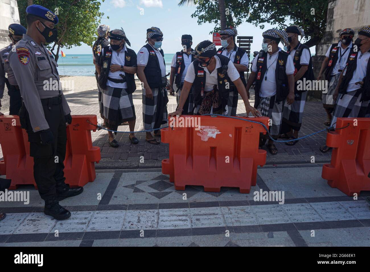 Denpasar, Indonésie. 3 juillet 2021. Des membres du personnel de sécurité traditionnel balinais, le pecalang, ont installé des blocs lors d'une fermeture de route dans le cadre des mesures de restriction locales COVID-19 au site touristique de Sanur Beach à Denpasar, Bali, Indonésie, le 3 juillet 2021. L'Indonésie a enregistré samedi 27,913 nouveaux cas de COVID-19 au cours des 24 dernières heures, un autre record de la pointe quotidienne, portant le total à 2,256,851, a déclaré le ministère de la Santé. Credit: Bisinglasi/Xinhua/Alamy Live News Banque D'Images