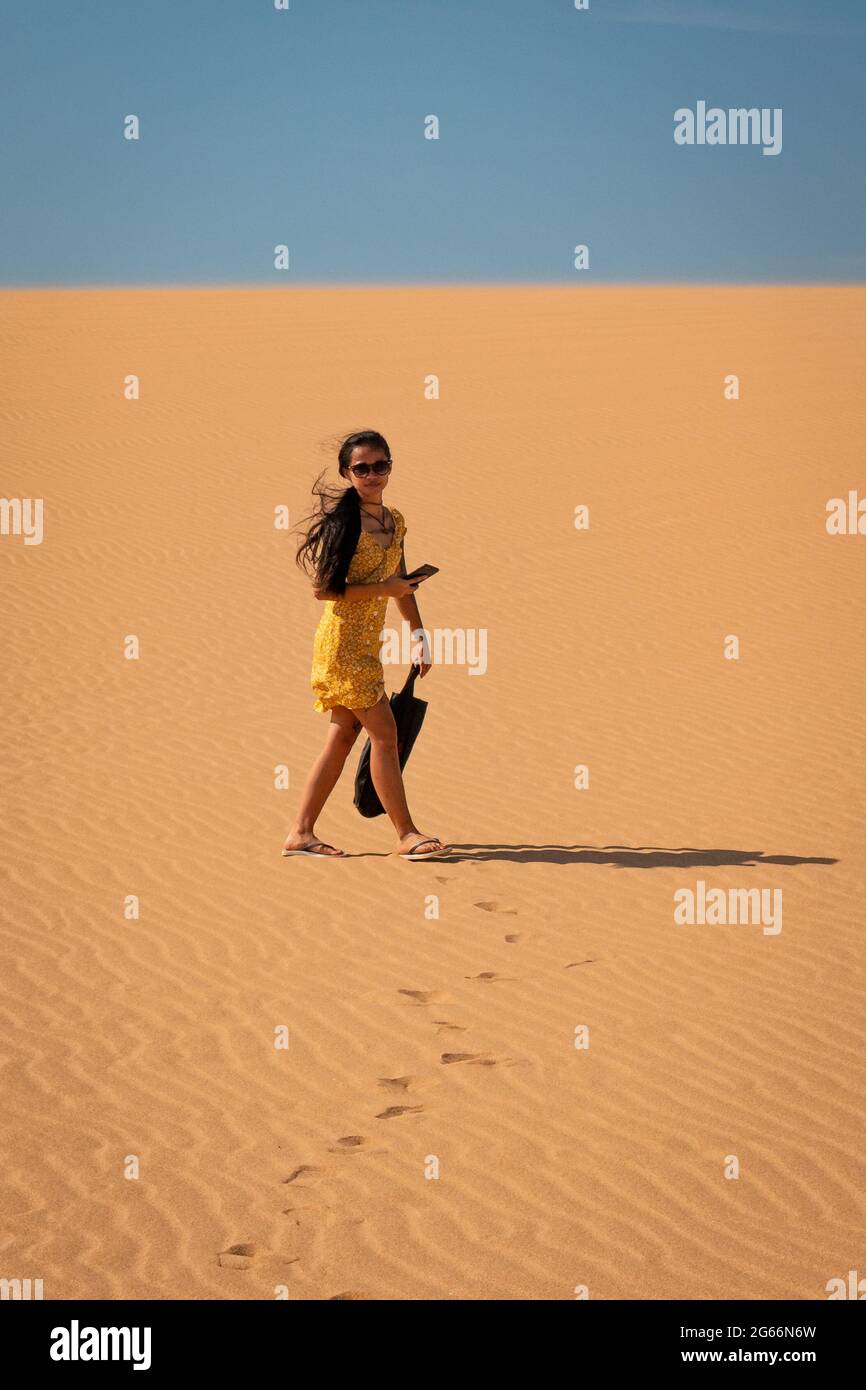 Une jeune femme asiatique attirante porte un sac à pied pour les dunes de Taroa Banque D'Images