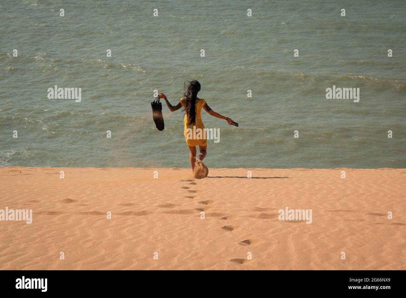 Une jeune femme asiatique attirante porte un sac à pied pour les dunes de Taroa Banque D'Images