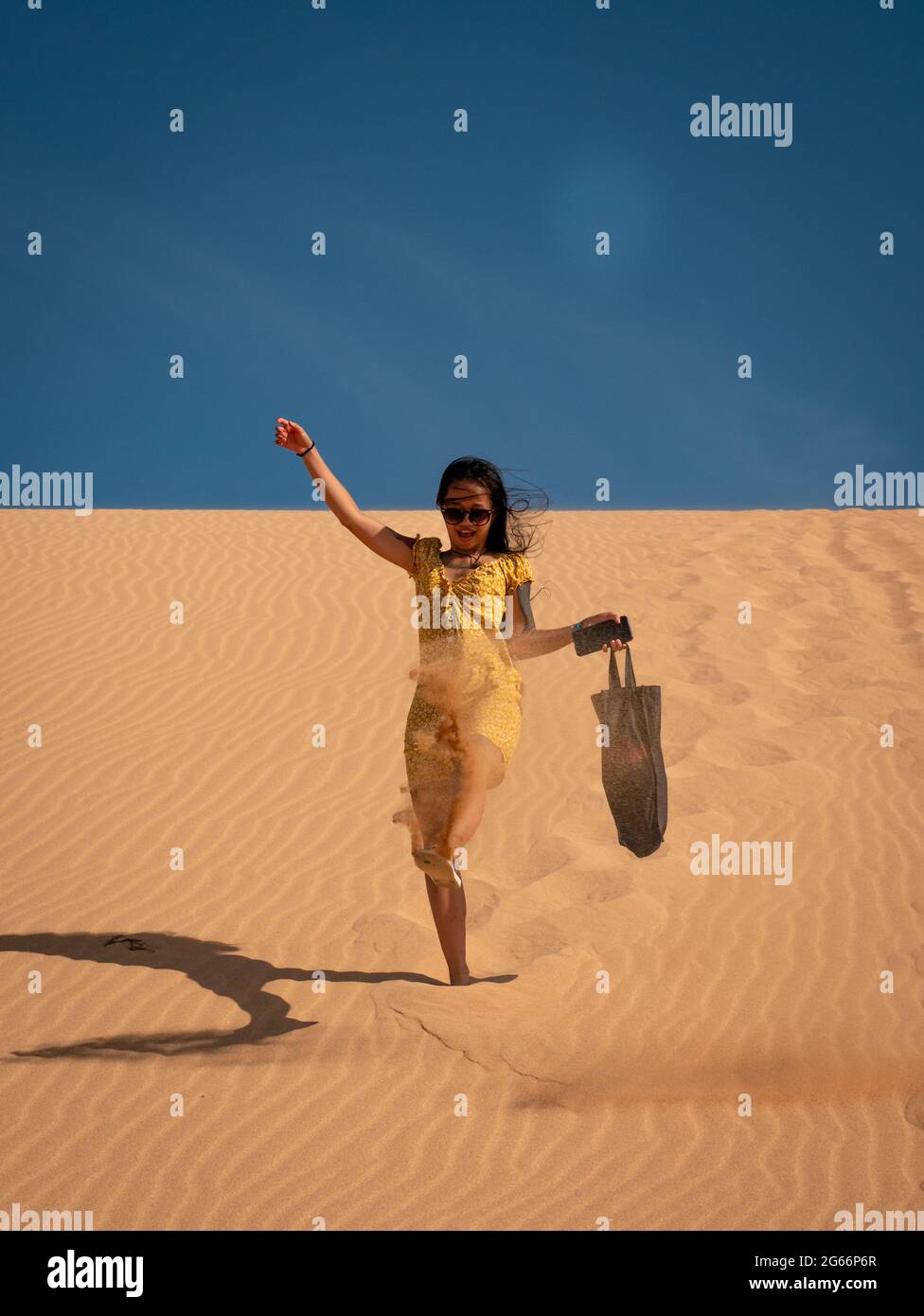 Une jeune femme asiatique attirante porte un sac à pied pour les dunes de Taroa Banque D'Images