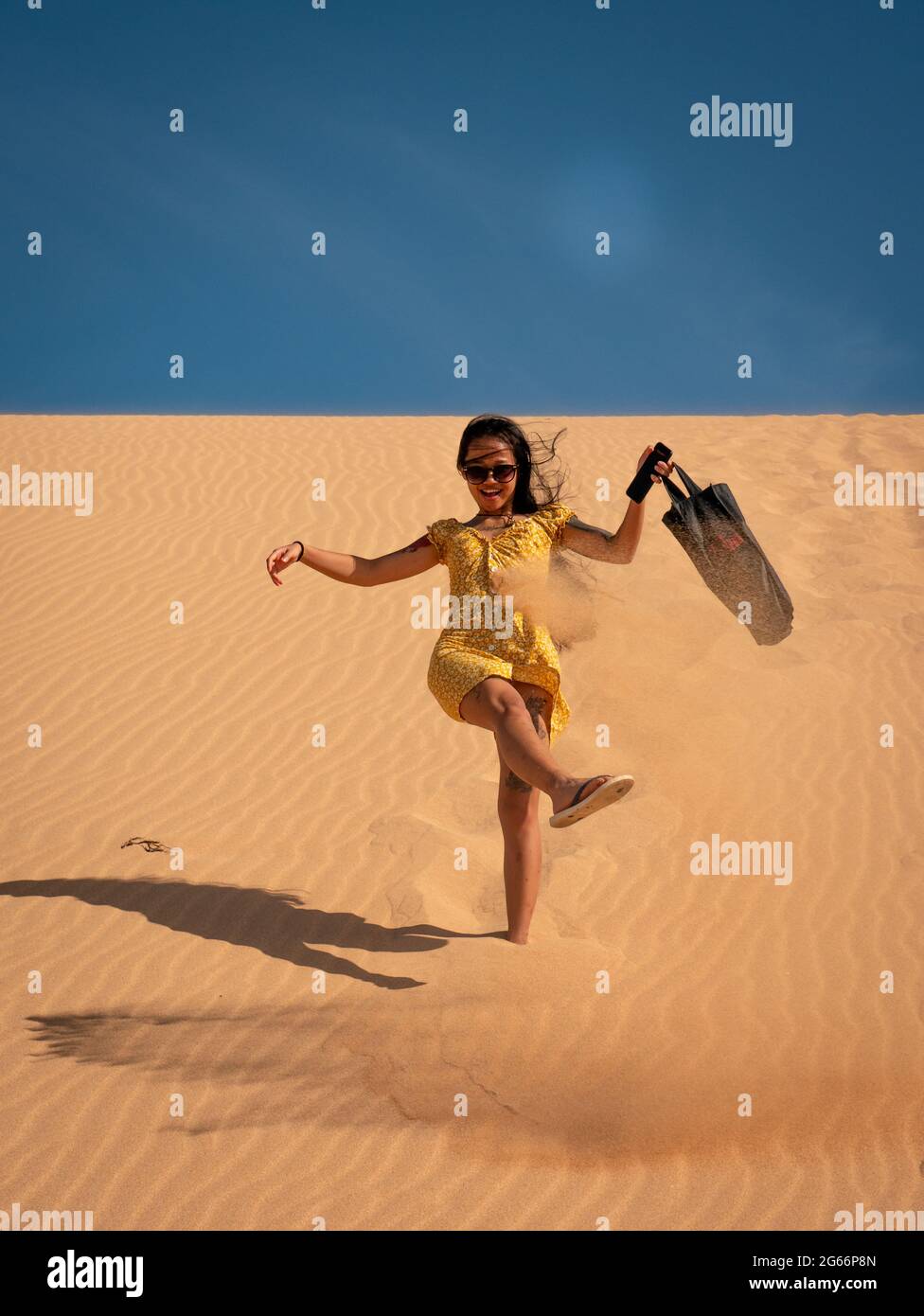 Une jeune femme asiatique attirante porte un sac à pied pour les dunes de Taroa Banque D'Images