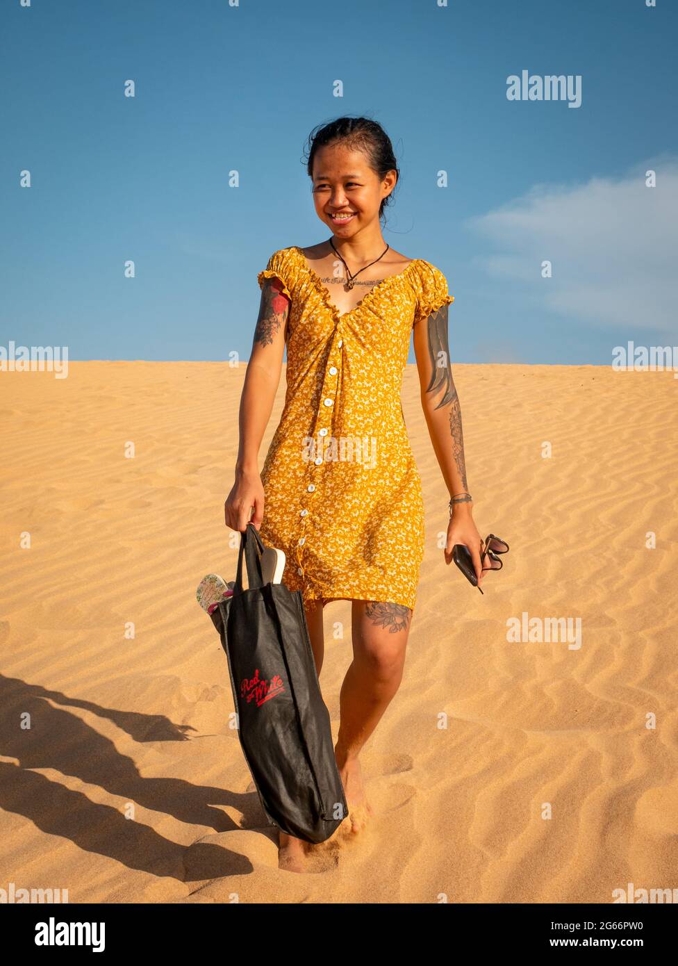 Uribia, la Guajira, Colombie - Mai 27 2021: Une jeune femme asiatique humide porte un sac après avoir glissé sur les dunes de Taroa et tomber dans l'eau de mer Banque D'Images