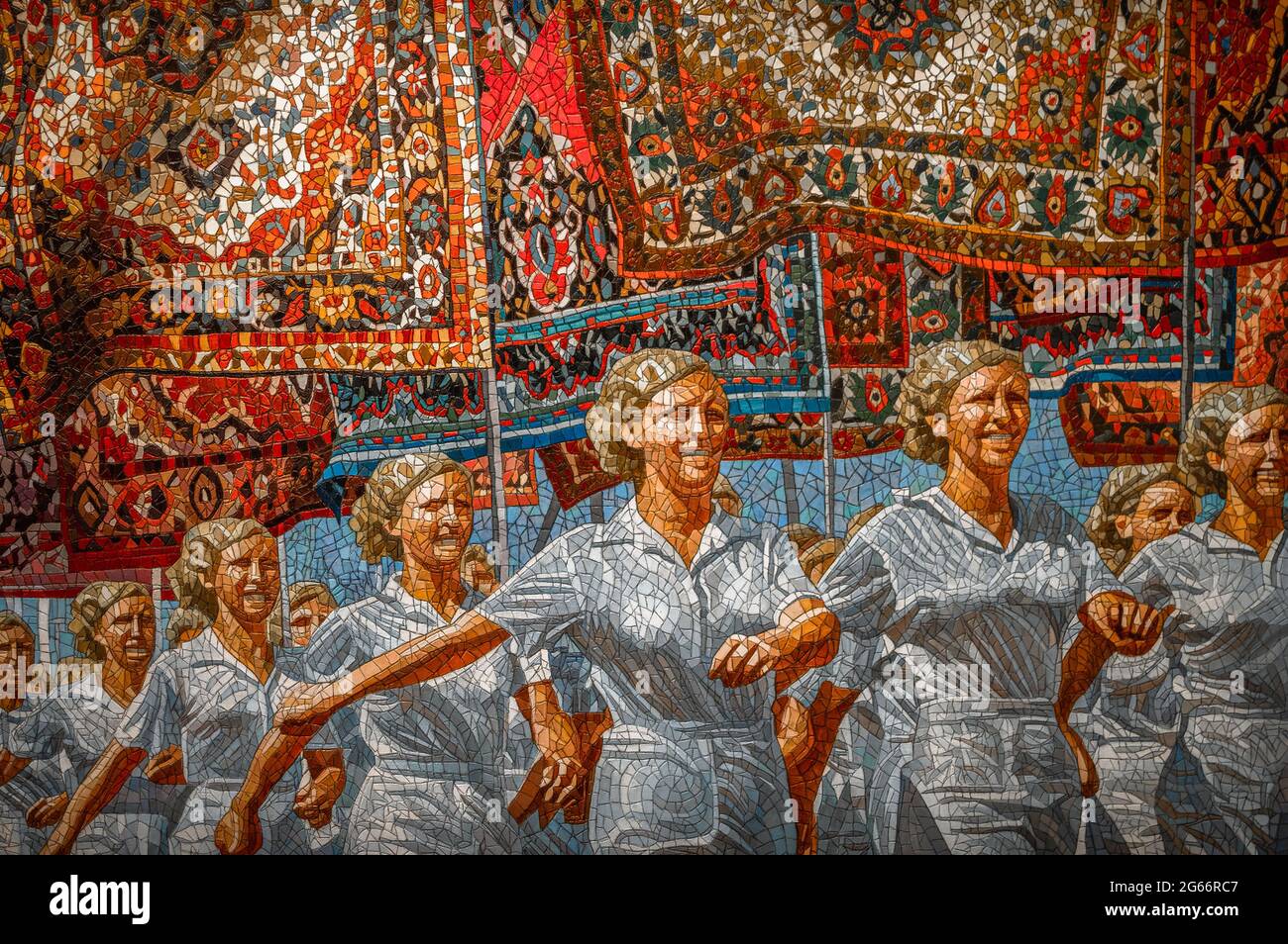 Marche de femmes soviétiques gaies tenant des tapis orientaux comme des drapeaux. Banque D'Images