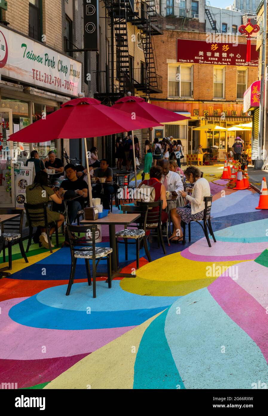 Les visiteurs de la rue Doyers à Chinatown à New York le jeudi 24 juin 2021 apprécient les « terrasses de riz » de Dasic Fernández dans le cadre du programme d'activités artistiques d'Asphalt. L'œuvre d'art de 4851 mètres carrés fait partie des efforts du Chinatown Partnership pour transformer la rue étroite et pittoresque en un centre commercial piétonnier. (© Richard B. Levine) Banque D'Images
