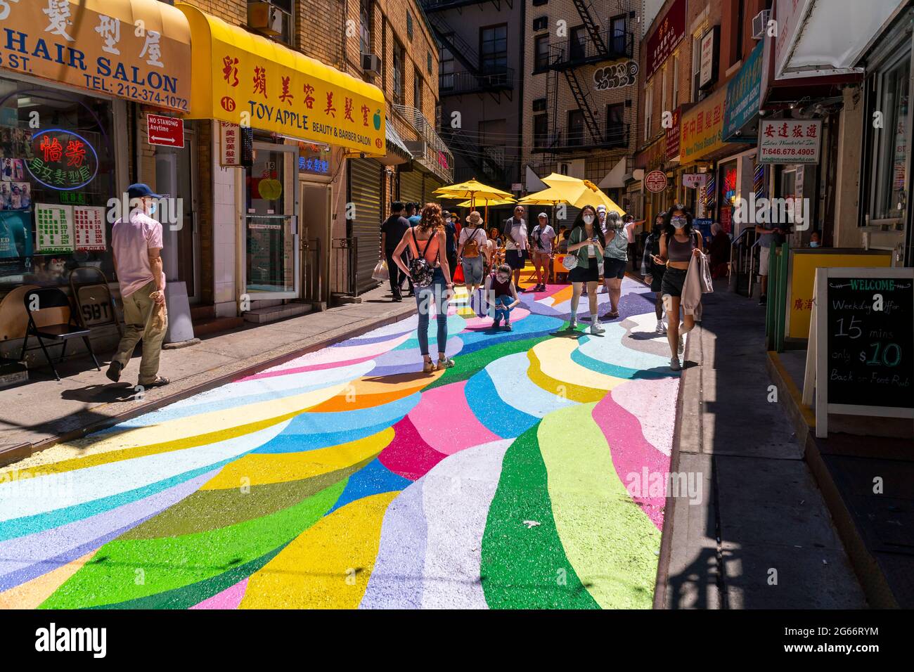Les visiteurs de la rue Doyers à Chinatown à New York le jeudi 24 juin 2021 apprécient les « terrasses de riz » de Dasic Fernández dans le cadre du programme d'activités artistiques d'Asphalt. L'œuvre d'art de 4851 mètres carrés fait partie des efforts du Chinatown Partnership pour transformer la rue étroite et pittoresque en un centre commercial piétonnier. (© Richard B. Levine) Banque D'Images