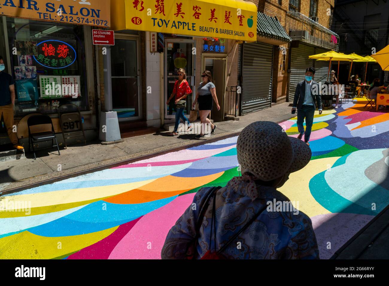 Les visiteurs de la rue Doyers à Chinatown à New York le jeudi 24 juin 2021 apprécient les « terrasses de riz » de Dasic Fernández dans le cadre du programme d'activités artistiques d'Asphalt. L'œuvre d'art de 4851 mètres carrés fait partie des efforts du Chinatown Partnership pour transformer la rue étroite et pittoresque en un centre commercial piétonnier. (© Richard B. Levine) Banque D'Images