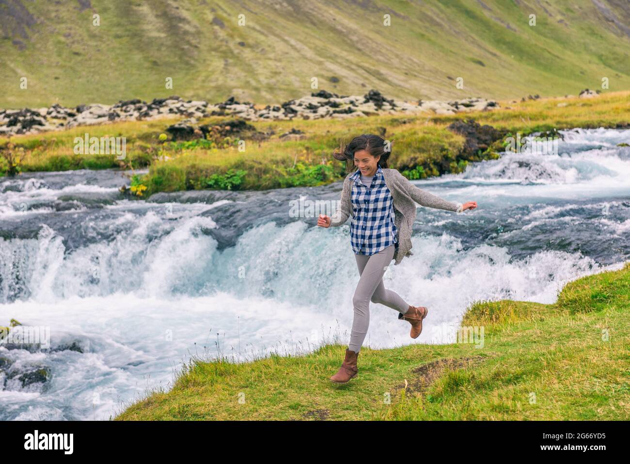 Femme joyeuse joyeuse joyeuse joyeuse aspirante joyeuse souriante en train de s'amuser en cascade sur l'Islande. Fille touriste dans des vêtements décontractés visite Banque D'Images