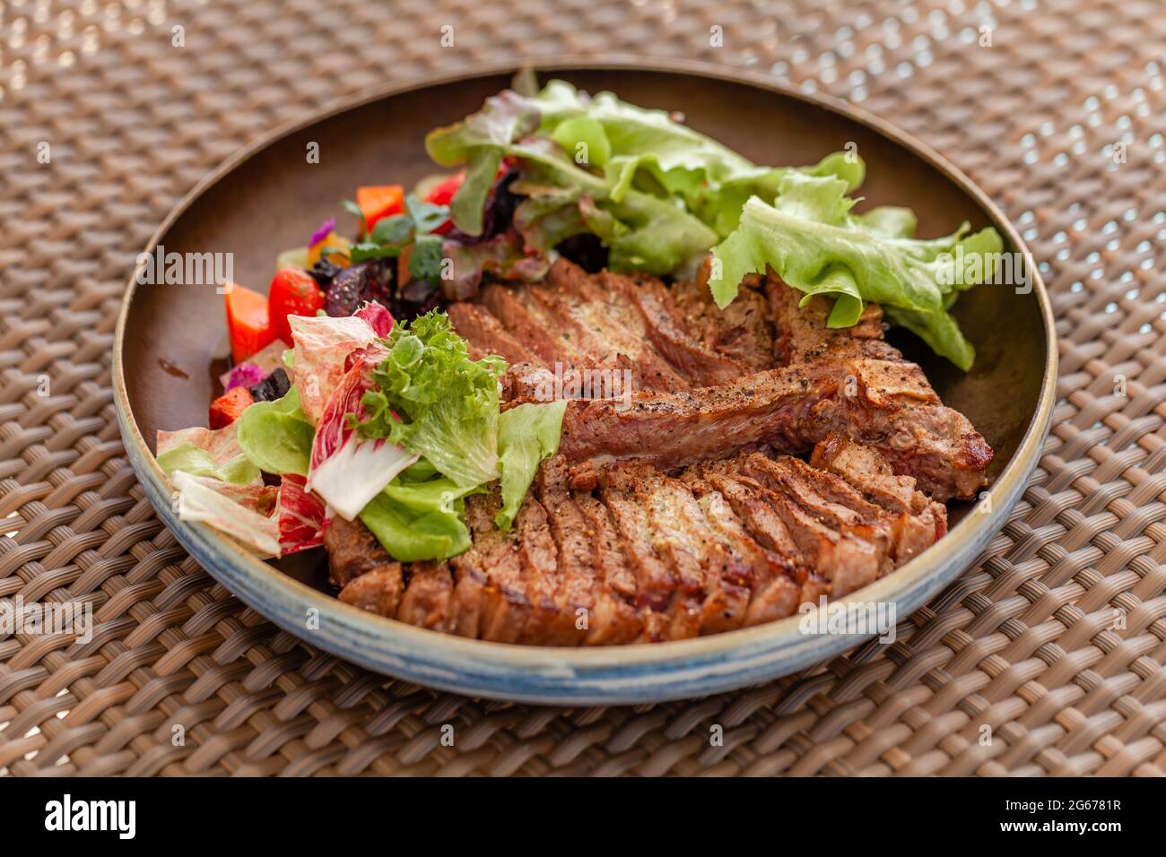 Steak de bœuf haché grillé servi avec salade et légumes au Beachfront Cafe Banque D'Images