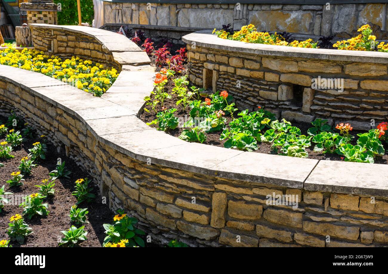 Aménagement paysager de beau jardin de maison, aménagement paysager avec murs de soutènement et parterres de fleurs dans l'arrière-cour de maison résidentielle. Bel aménagement extérieur Banque D'Images