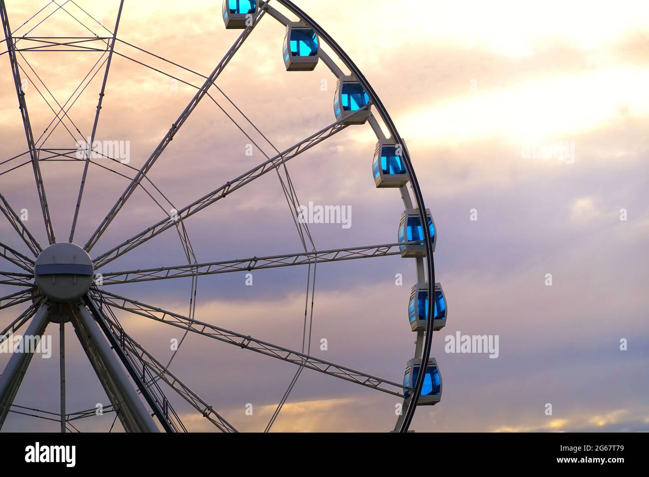 Une grande roue avec un beau ciel nuageux coloré. Grande roue au coucher du soleil avec espace de copie. Amusez-vous et amusez-vous. Banque D'Images