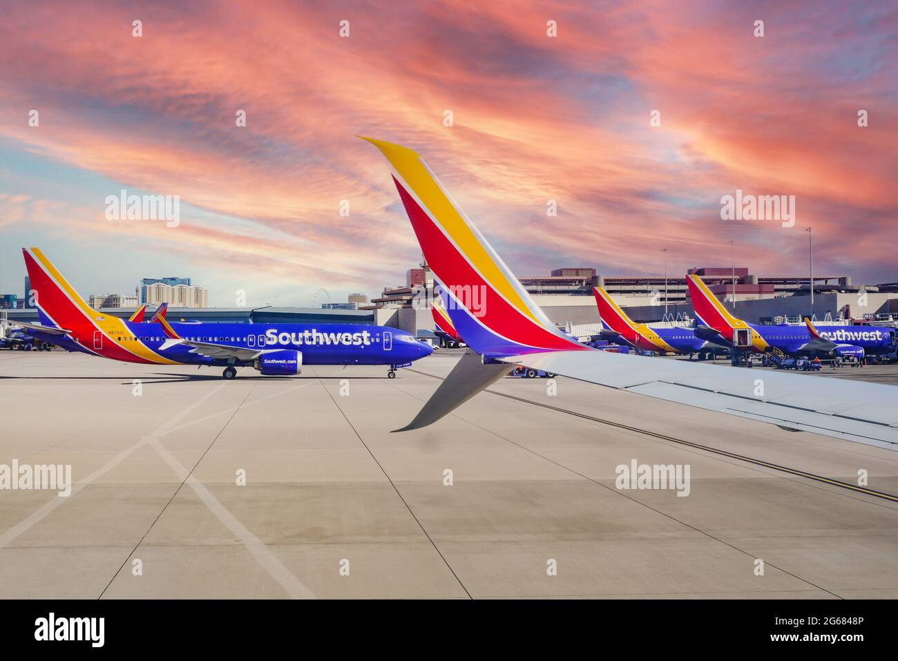 Une formation d'avions Southwest Airlines aux portes du terminal de l'aéroport international McCarran de Las Vegas, Nevada, avec des casinos au loin Banque D'Images