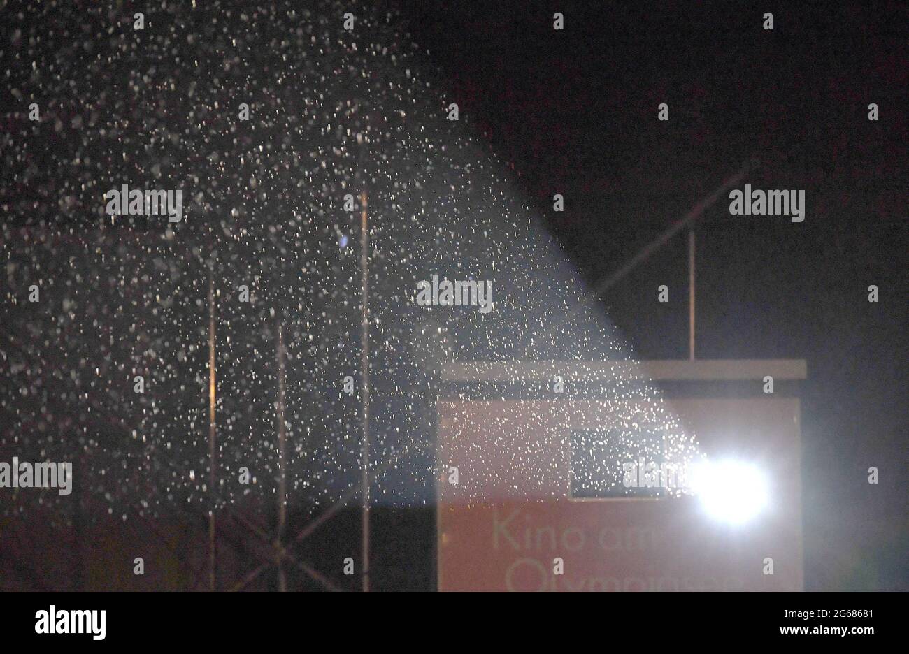 Munich, Allemagne. 03ème juillet 2021. La pluie peut être vue à la lumière du projecteur de film au Festival International du film de Munich au Kino am Olympiasee (Open Air). Credit: Felix Hörhager/dpa/Alay Live News Banque D'Images