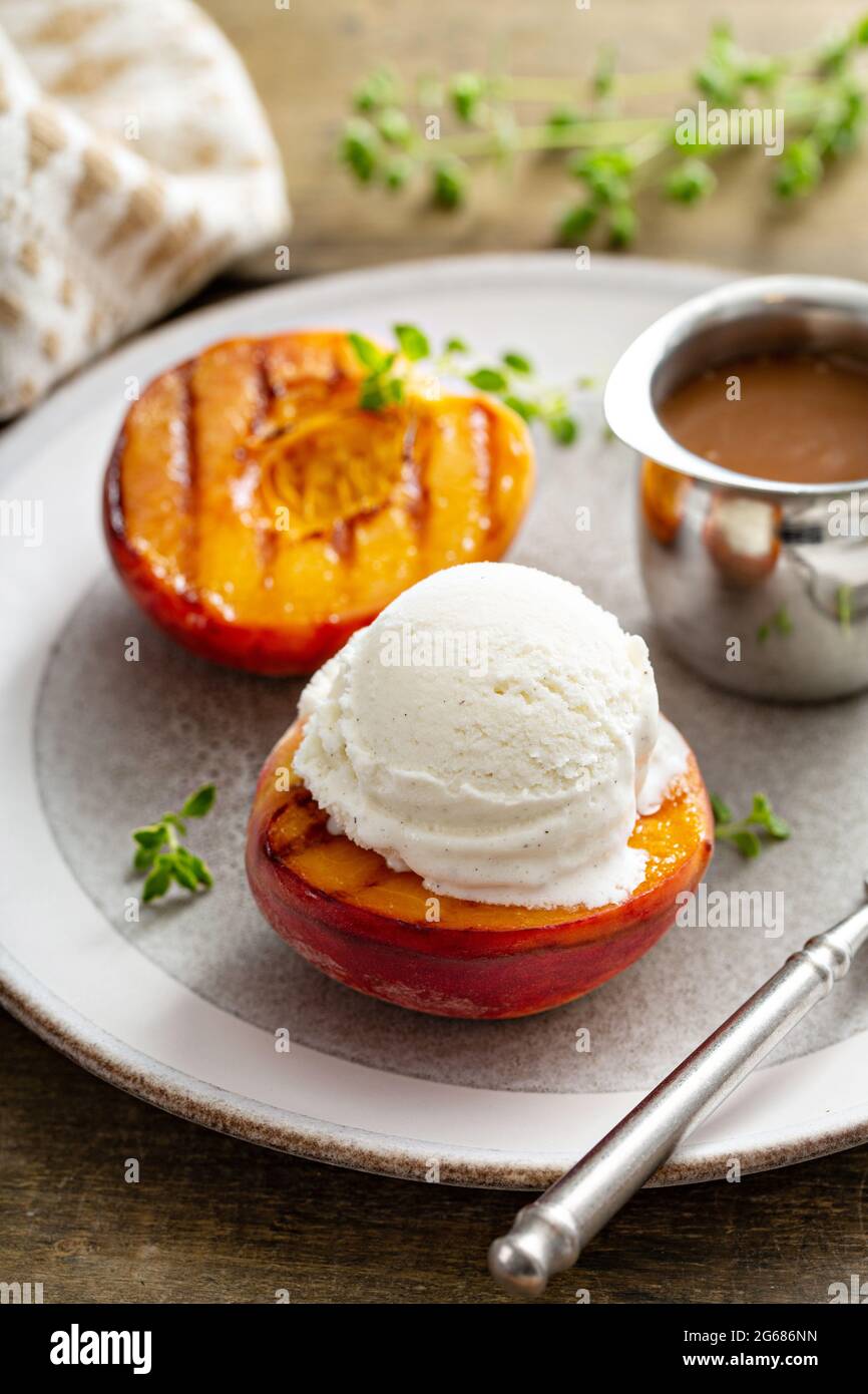 Pêches grillées à la crème glacée et sauce caramel, dessert d'été Banque D'Images