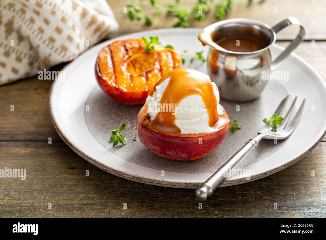 Pêches grillées à la crème glacée et sauce caramel, dessert d'été Banque D'Images