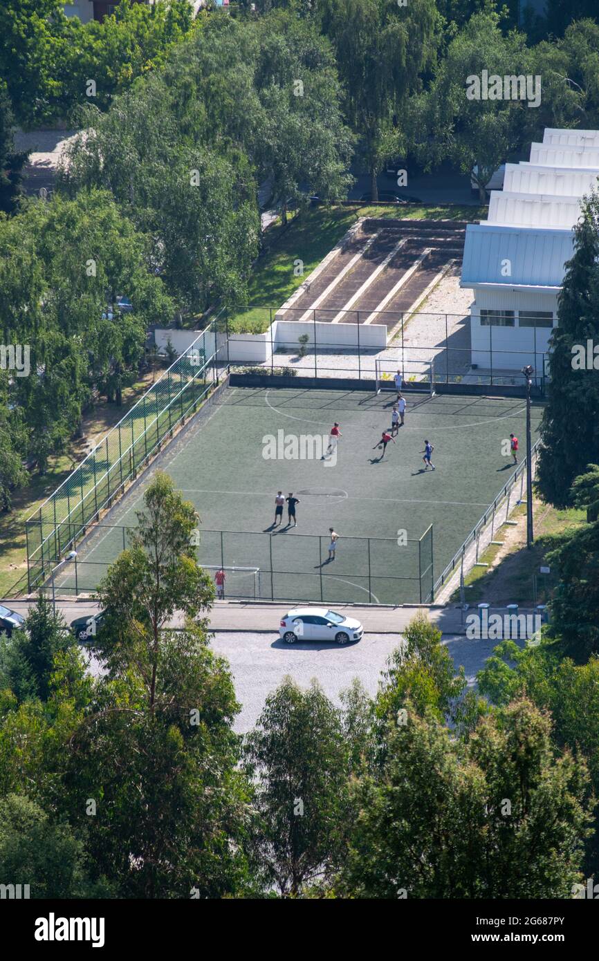Enfants ou adolescents jouant au football dans les terrains de football de la ville Banque D'Images