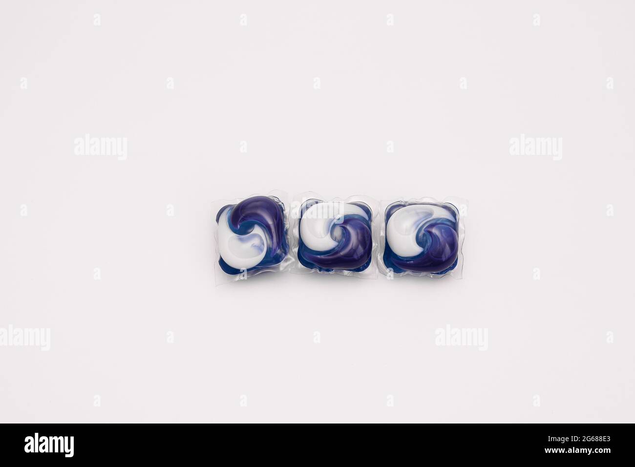 Capsules de gel pour lave-linge. Trois dosettes bleues. Banque D'Images