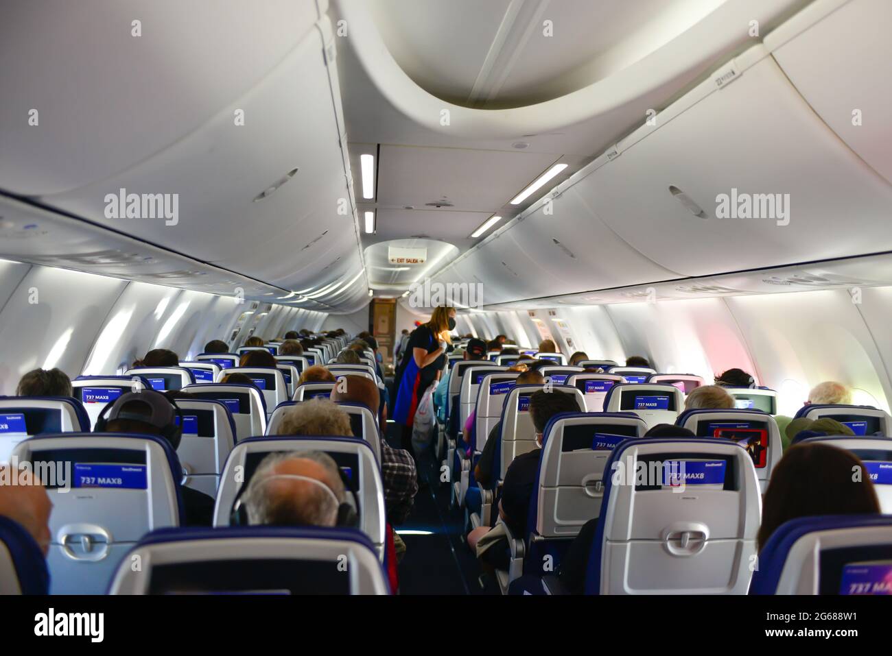 Vue de l'arrière de l'avion de l'agent de vol en cabine d'un avion commercial 737 Max chargé de passagers, le Max rentrant récemment à servi Banque D'Images