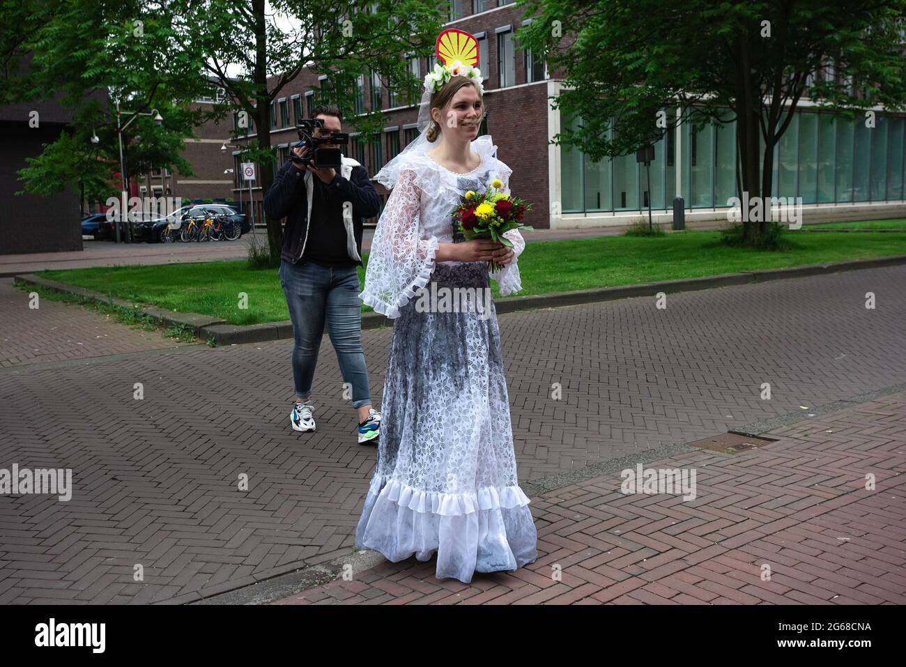 La mariée de 'Shell' fait son entrée en face du siège de Shell à la Haye.extinction rébellion NL, a initié un événement théâtral symbolique ce matin devant le siège de Shell aux pays-Bas, un mariage symbolique a été organisé entre le Premier ministre Mark Rutte et Shell. Des années de discussions à oreiller entre les deux et leurs points de vue communs ont peu fait pour le changement climatique. Extinction État de la rébellion : les crises climatiques et écologiques exigent trois choses : (1) être honnête, (2) faire ce qui est nécessaire et (3) laisser les citoyens décider. Le lobbying des grands pollueurs comme Shell doit cesser de faire du lobby, c Banque D'Images