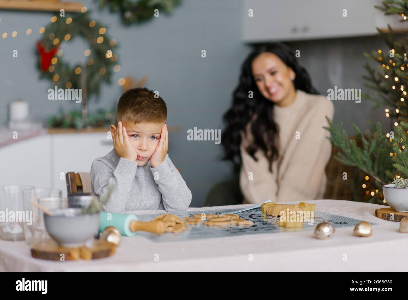 Maman et son fils font des visages et ont plaisir à préparer des biscuits de Noël dans la cuisine Banque D'Images