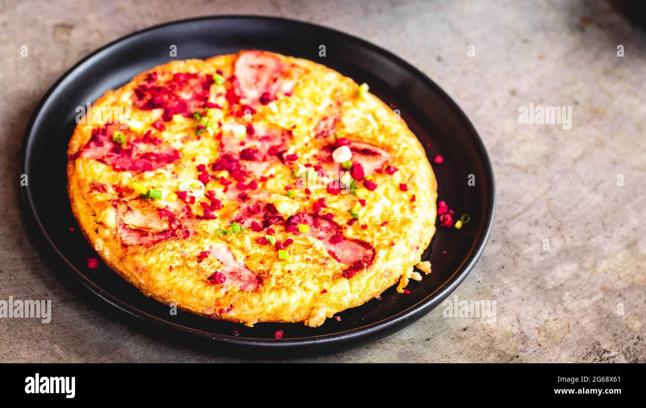 Omelette espagnole Frittata faite d'œufs bacon paprika persil pois vert oignon fromage pour la nourriture délicieuse. Banque D'Images