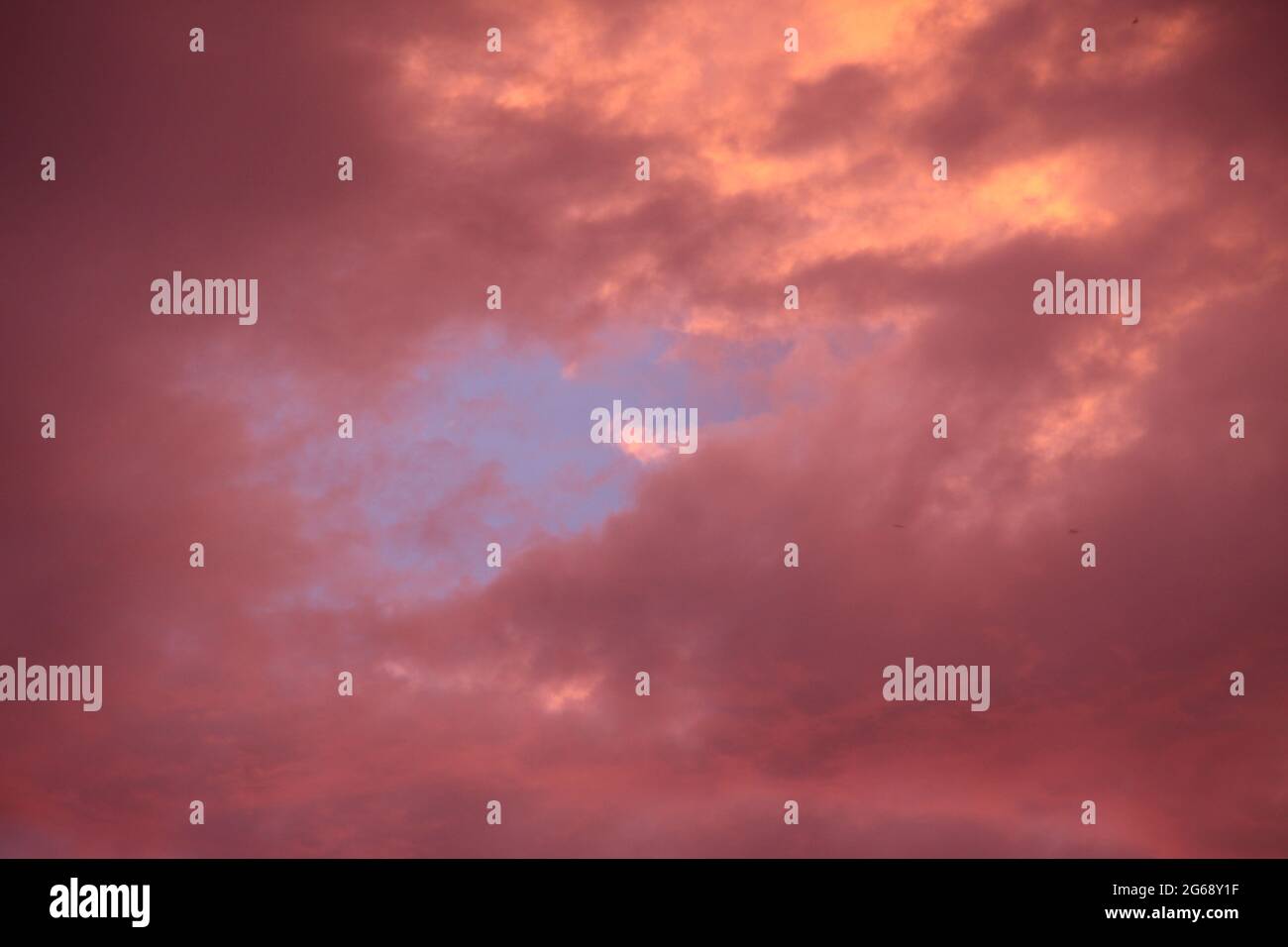 Nuage rouge avec bleu trou coucher de soleil, Allemagne Banque D'Images