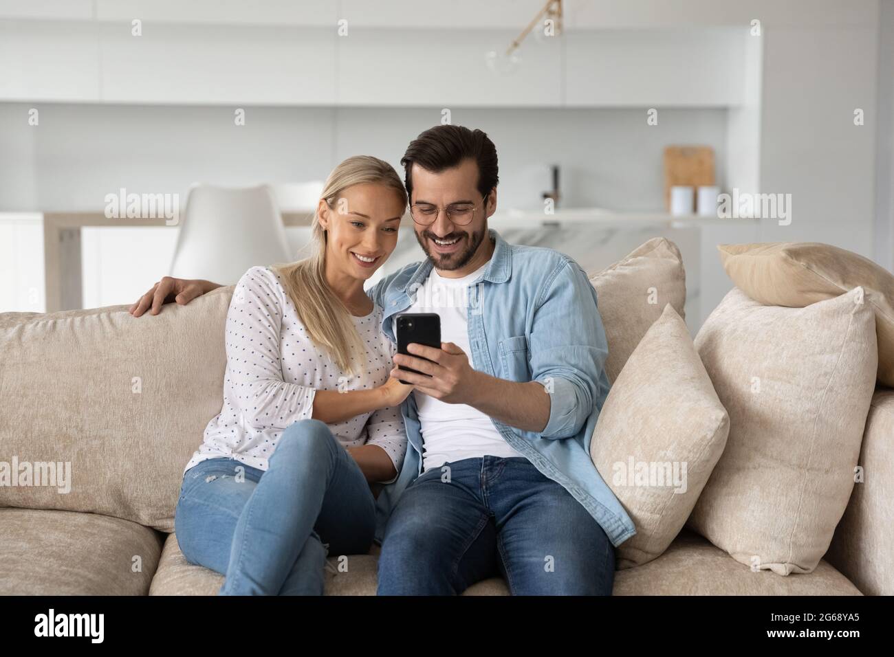 Un jeune couple heureux homme et femme utilisant un smartphone ensemble Banque D'Images