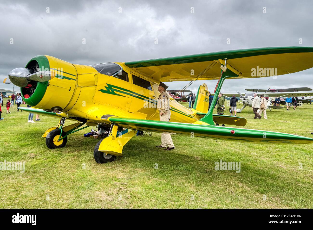 Un homme en uniforme de l'armée inspecte un Beechcraft 17S Stagerwing, NC 18028, de 1937, à Middle Wallop, Hampshire, au Royaume-Uni Banque D'Images