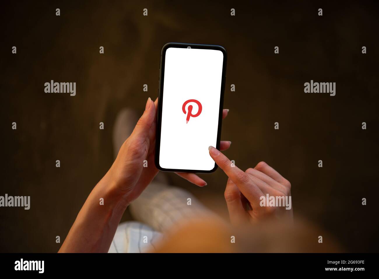 Riga, Lettonie - 3 juillet 2021 : femme tenant un téléphone portable avec le logo Pinterest à l'écran Banque D'Images