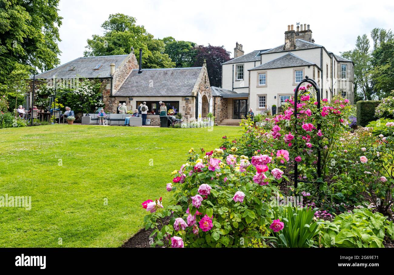 East Lothian, Écosse, Royaume-Uni, 4 juillet 2021. Scotland's Garden Scheme nouveau jardin ouvert: Shane Corstorphine, ancien directeur financier de Skyscanner et un jardinier passionné, a passé 4 ans à préparer les jardins de Camptoun House pour la première fois à recueillir de l'argent pour un jardin clos à Gilmerton. Il y a un jardin de cuisine, un jardin clos, un verger et un sentier de fées. Plus de 400 personnes ont visité le jardin pendant le week-end malgré la forte pluie hier. Photo: Les gens aiment le thé et le café dans le jardin clos avec une vue sur la maison de campagne géorgienne Banque D'Images