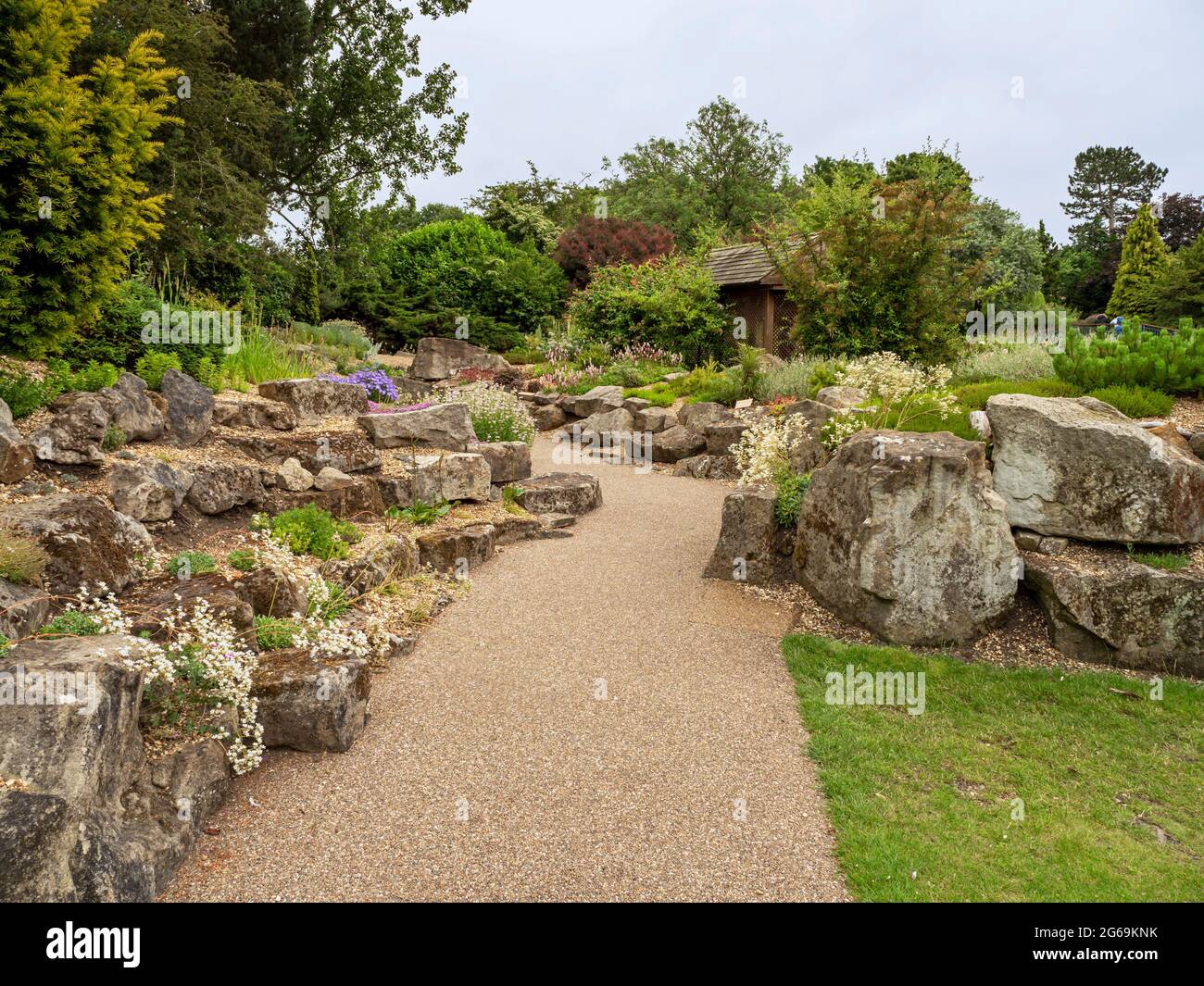 Chemin à travers un jardin de rochers avec des plantes et des arbres Banque D'Images