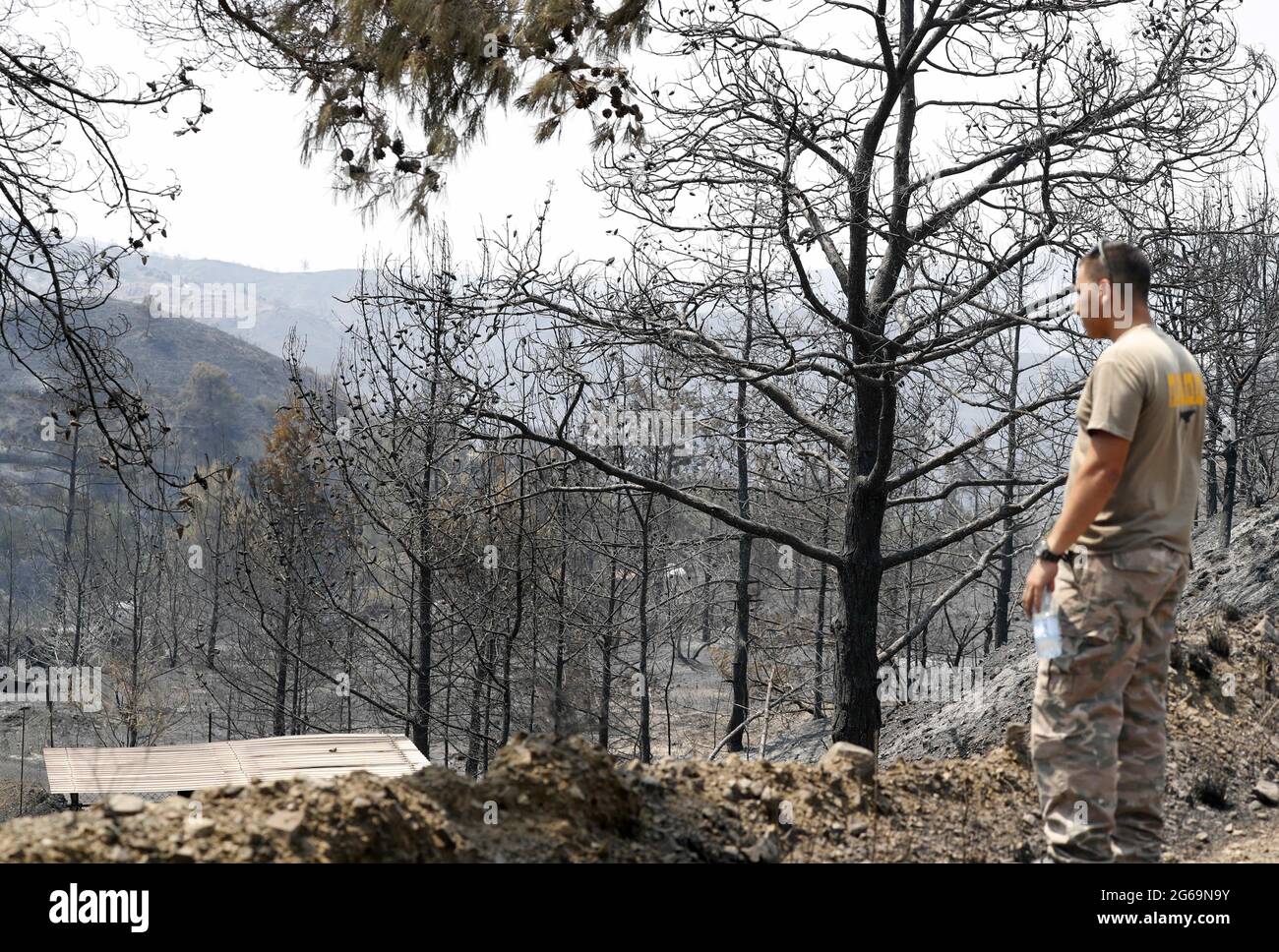 Larnaca, Chypre. 4 juillet 2021. Un homme se tient près d'une zone brûlée dans le village d'Ora, dans le district de Larnaca, Chypre, le 4 juillet 2021. Quatre personnes ont été tuées dans un incendie de forêt de mammouth qui fait rage depuis près de 24 heures dans une zone montagneuse de Chypre, a déclaré la police dimanche. Credit: George Christophorou/Xinhua/Alay Live News Banque D'Images