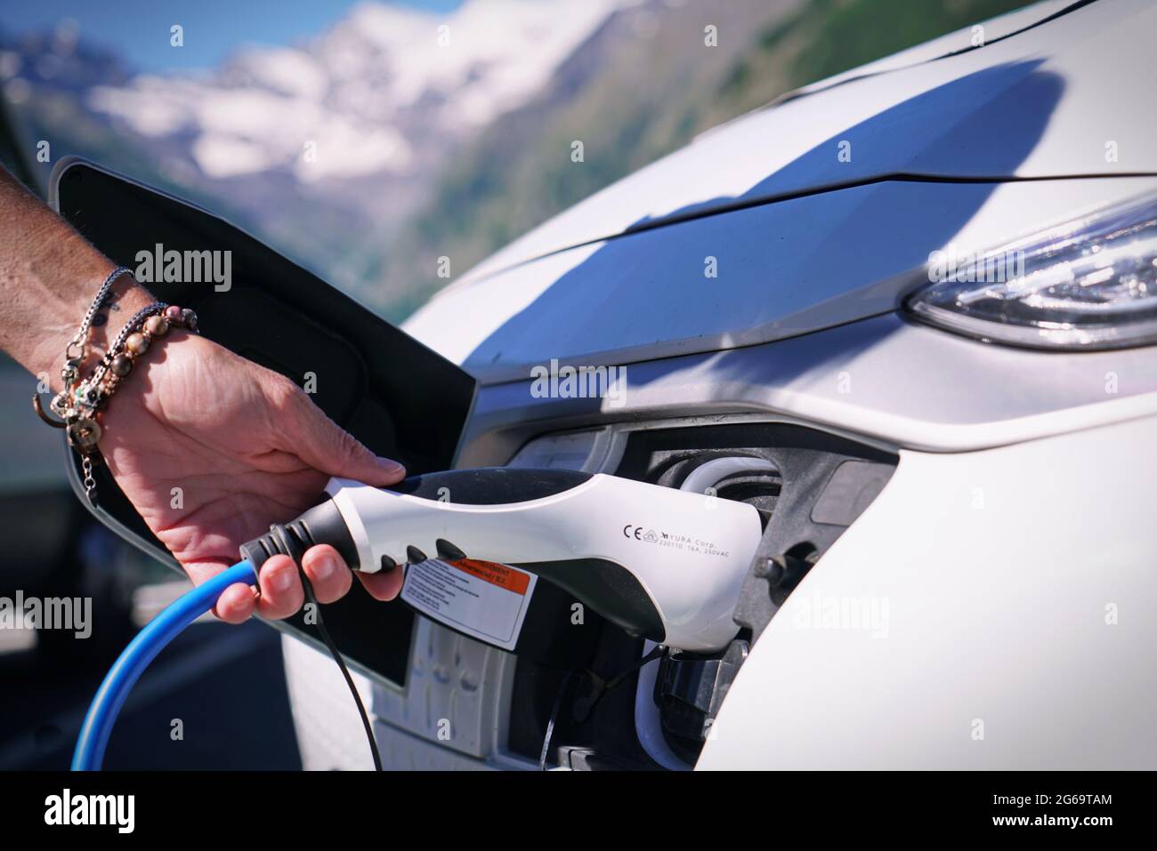 Voiture électrique de charge de sa batterie avec le paysage naturel, pour l'environnement vert, l'écologie, le développement durable, l'air propre, futur. Bolzano, Italie - juillet 202 Banque D'Images